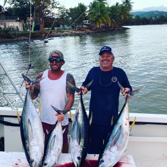 a person holding a fish on a boat in a body of water