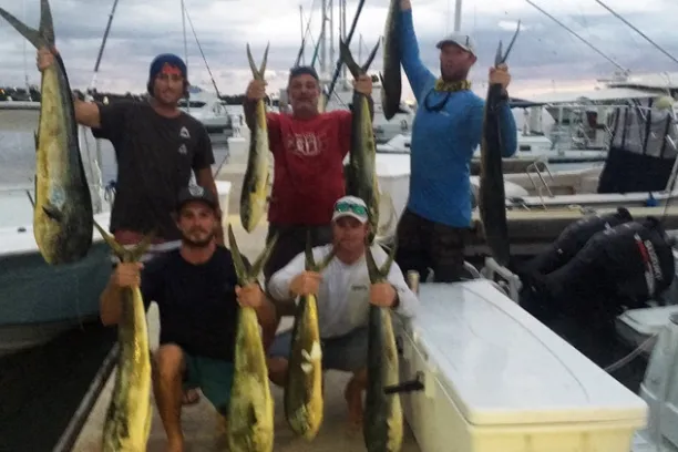 a man holding a fish on a boat